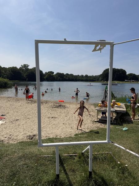 This vibrant outdoor scene captures a sunny summer day at Haarweg, Vuren, where numerous people are enjoying a recreational lake